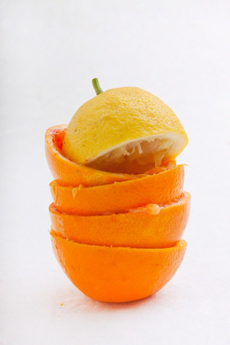 Stapel von ausgepressten Orangenschalen & Zitronenhälfte