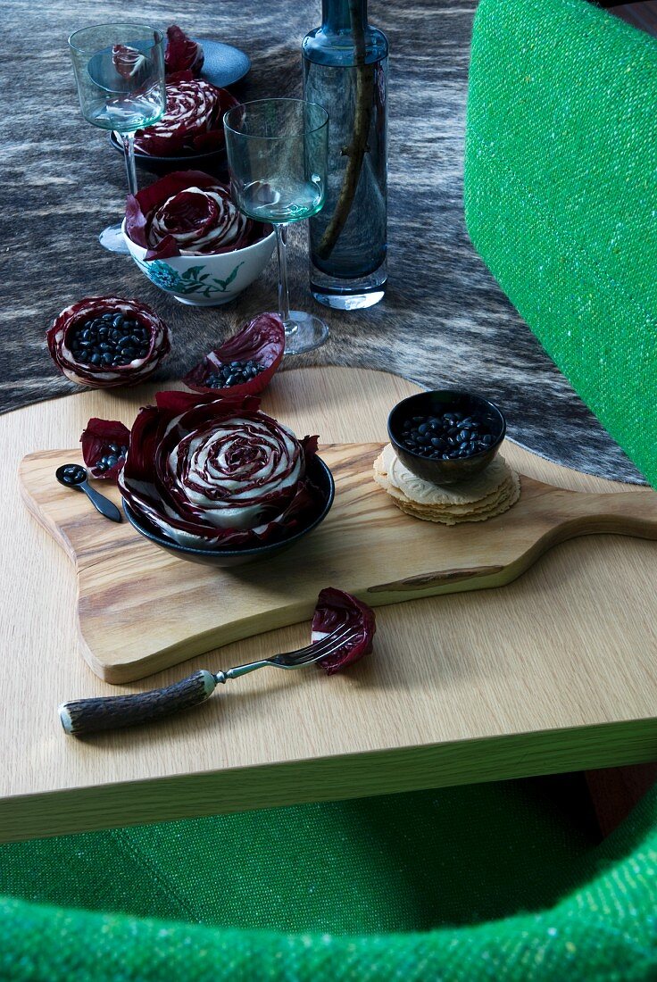 Autumnal table decoration of halved radicchios and black beans