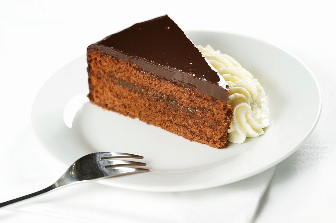 Slice of Sacher torte with whipped cream