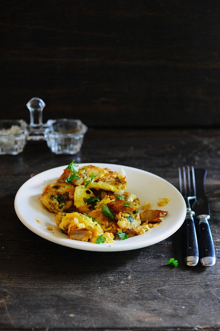 Gröstl mit Kartoffeln, Schweinefleisch, Ei und Petersilie