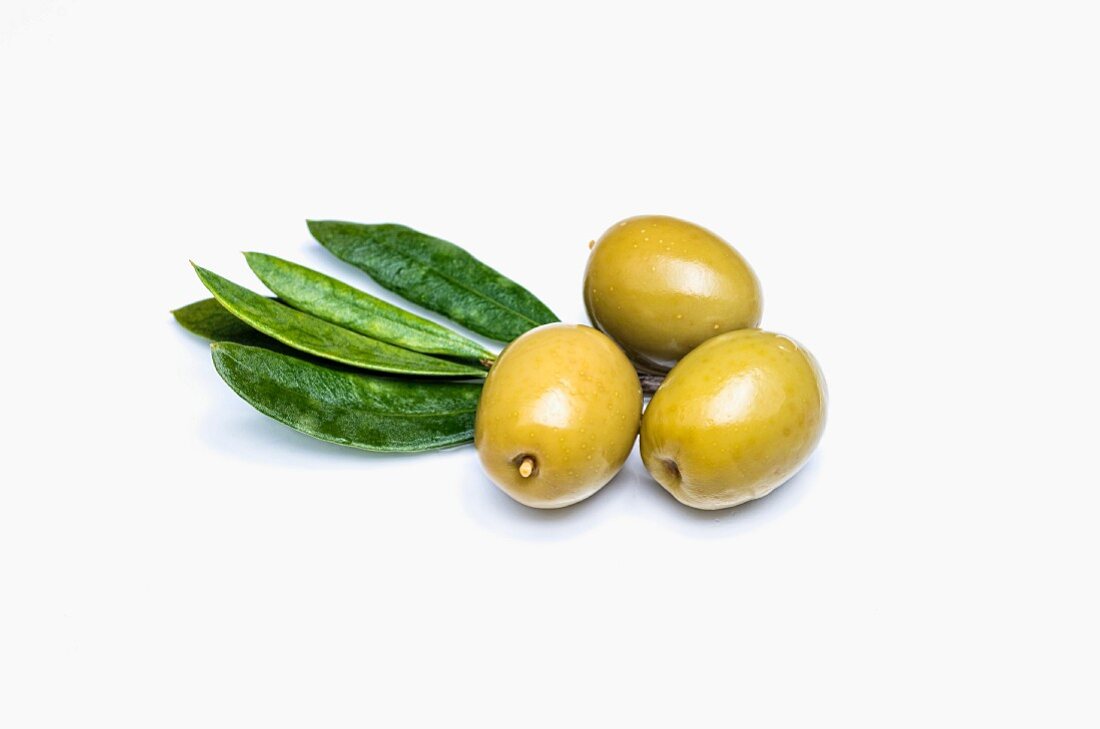 Three green olives on a white background