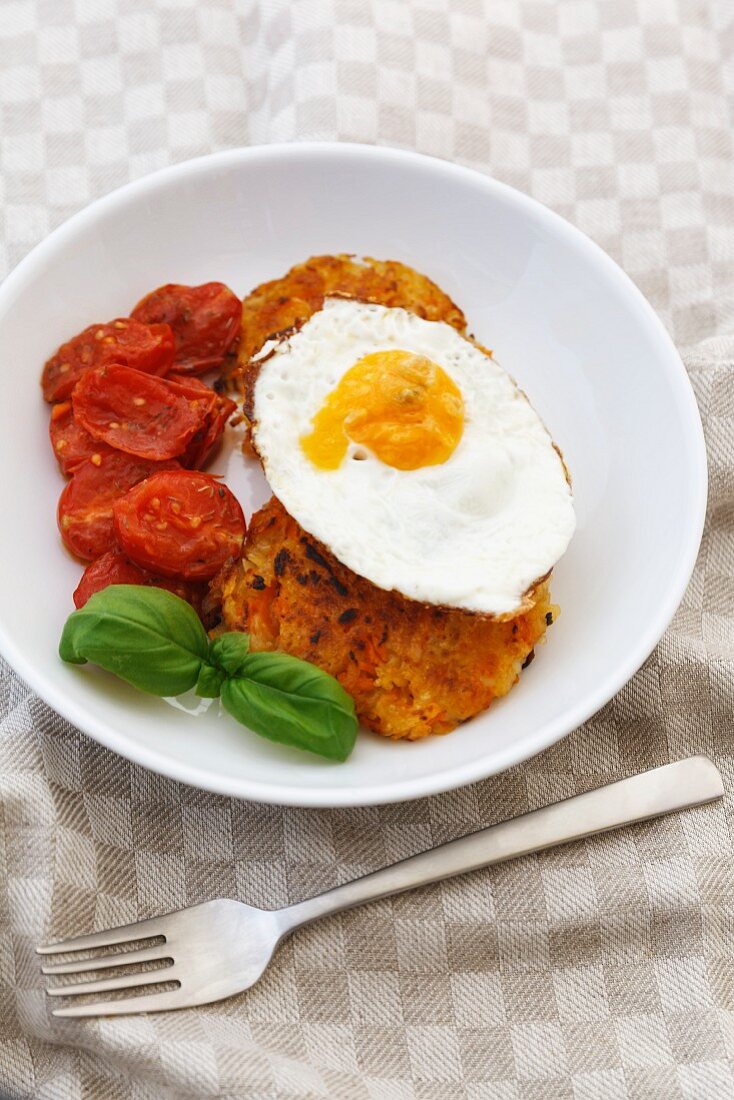 Carrot fritter with a fried egg and braised tomatoes