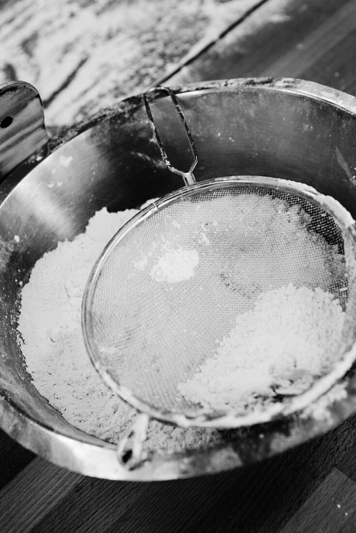 A mixing bowl and a sieve with flour