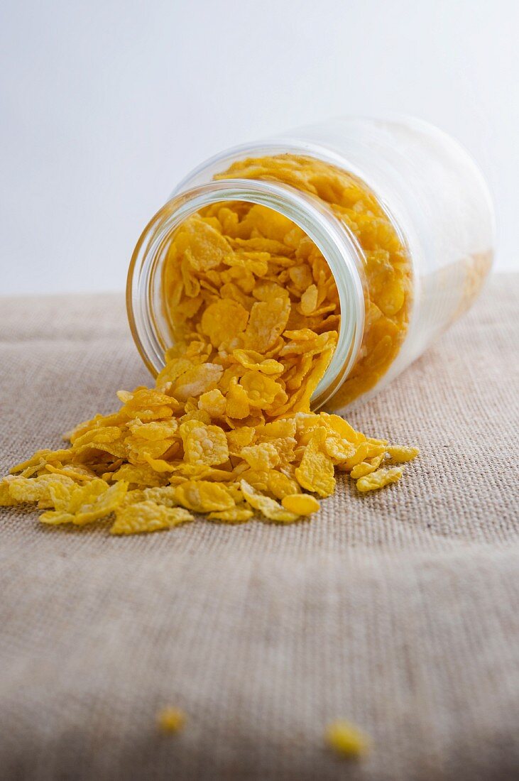 Cornflakes falling out of an overturned jar