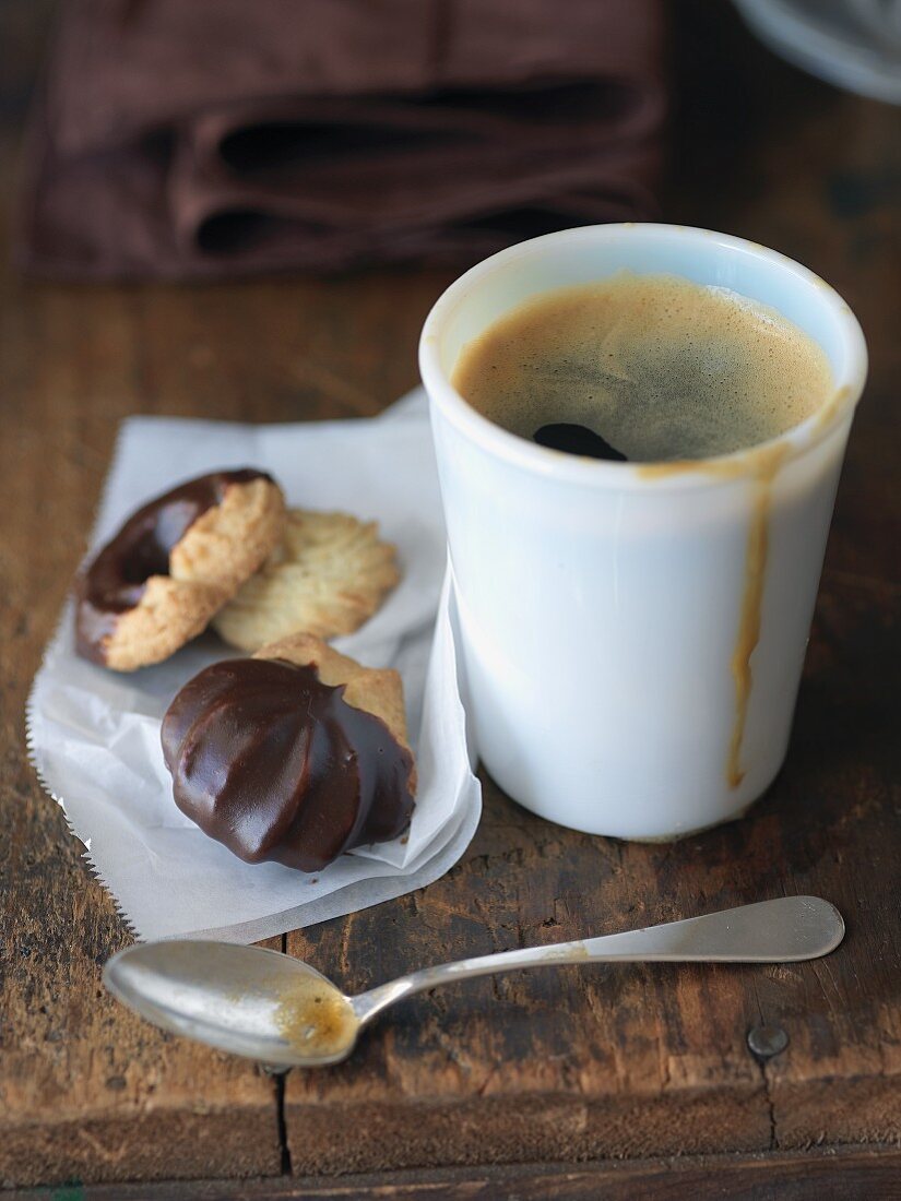 A mug of espresso served with biscuits