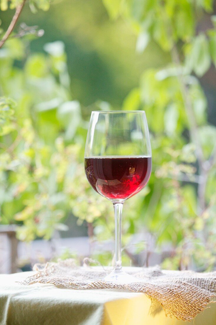 A glass of red wine on a garden table
