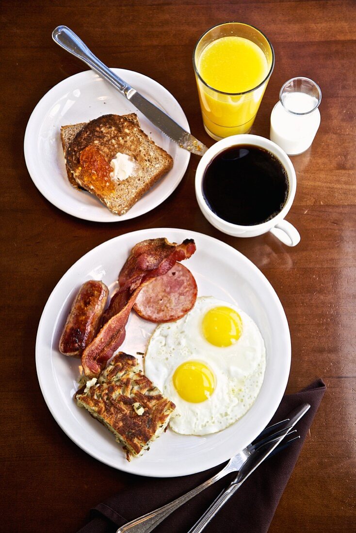 Amerikanisches Frühstück mit Spiegeleiern, Speck & Würstchen