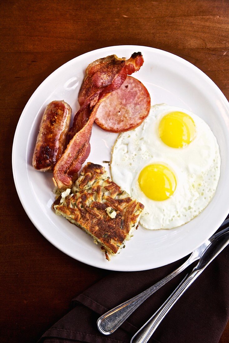 Amerikanisches Frühstück mit Spiegeleiern, Speck & Würstchen