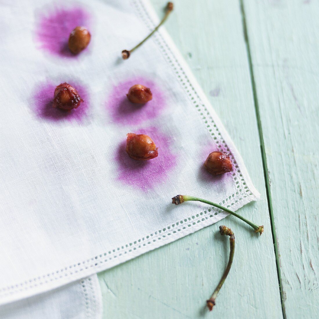 Cherry stones and stems on a white cloth