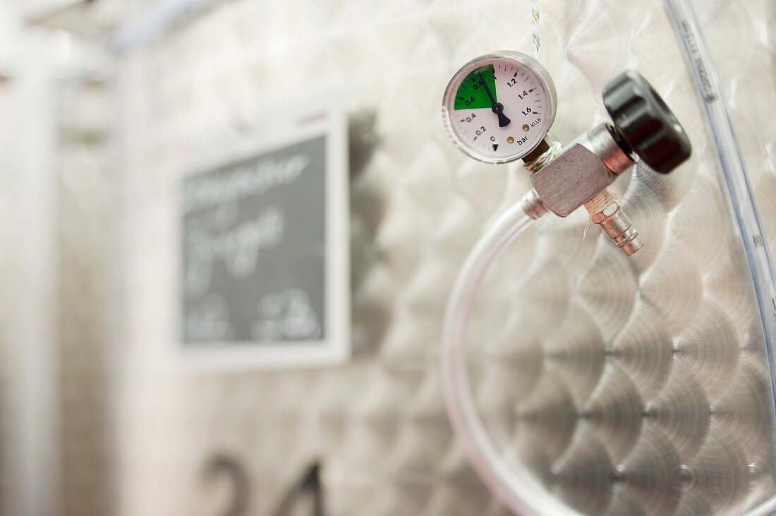 A pressure valve on a stainless steel tank in a winery