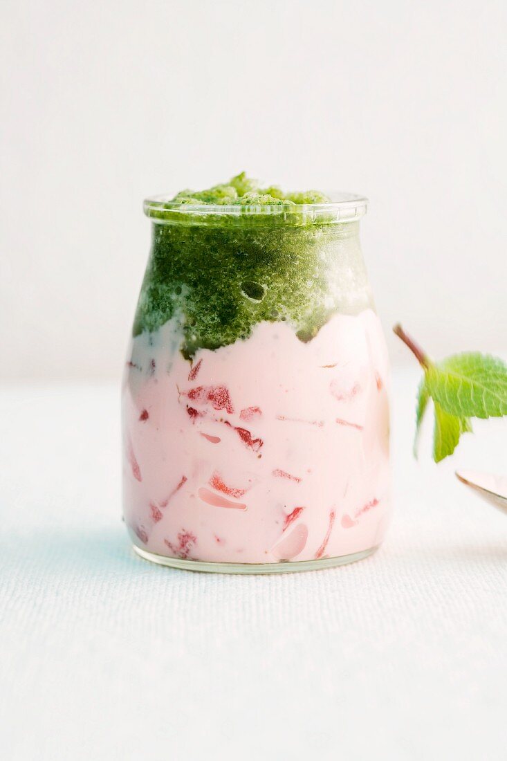 A glass of strawberry yogurt with mint granita
