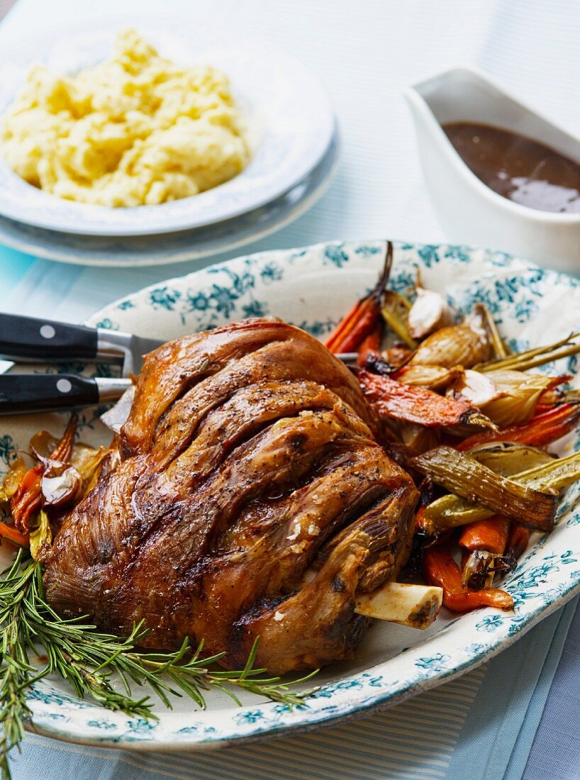 Roast shoulder of lamb with vegetables, rosemary, mashed potatoes and gravy