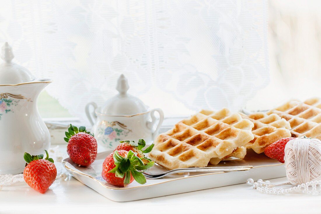 Belgische Waffeln mit Erdbeeren auf Fensterbrett