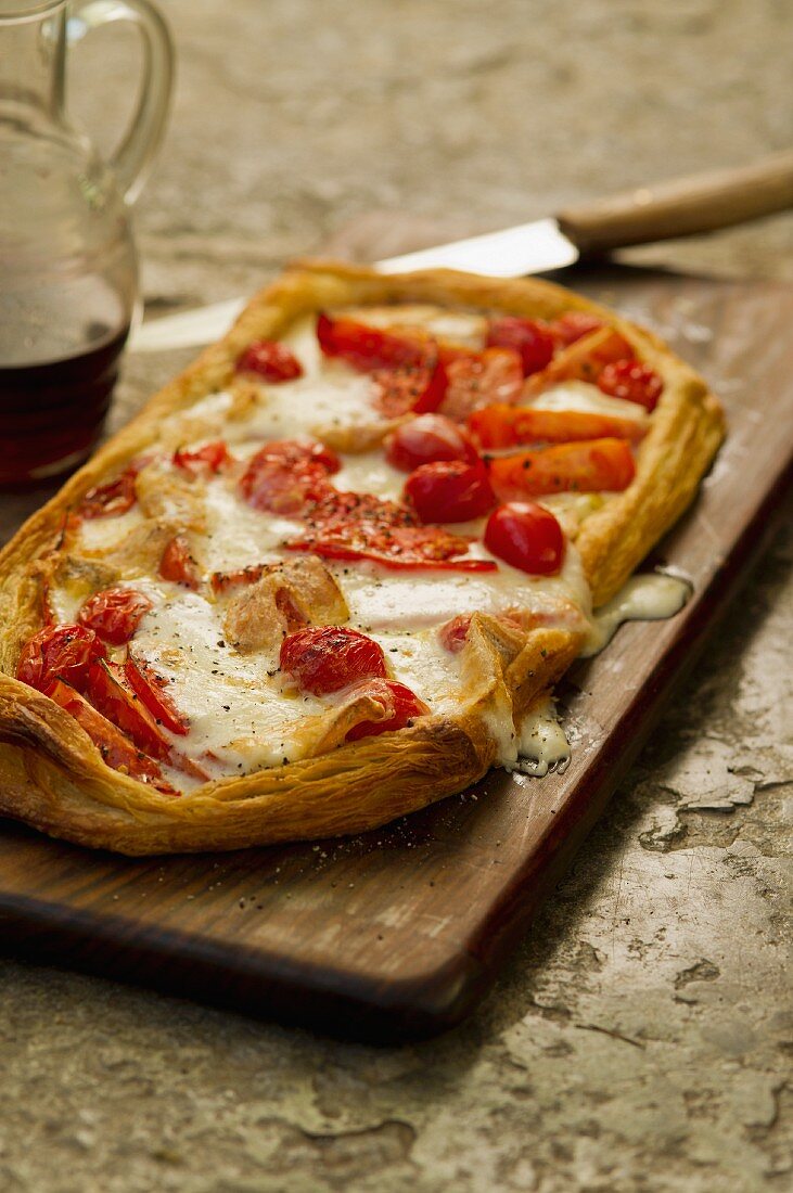 Tomato tart with cheese on a chopping board