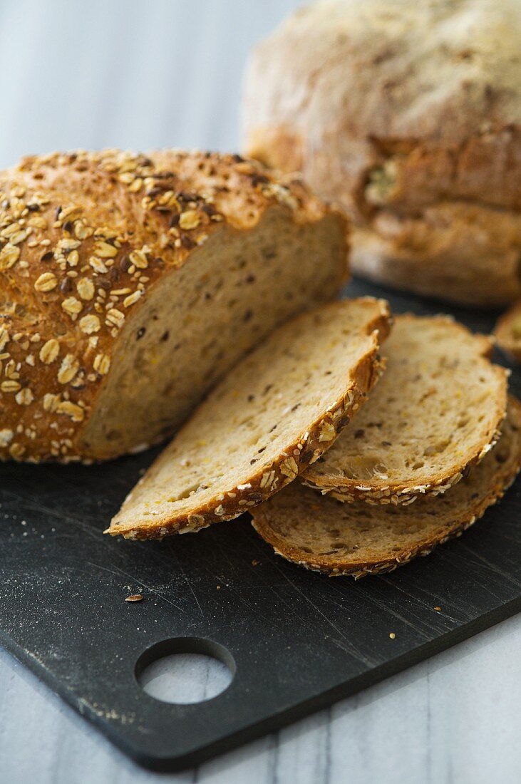 Seed bread with rolled oats, partly sliced