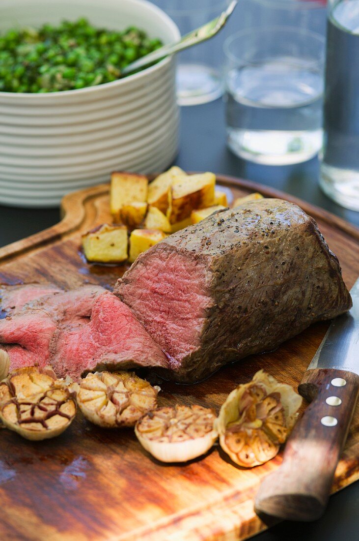 Roast beef with garlic, potatoes and peas