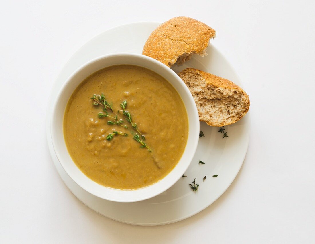 Creamer vegetable soup with thyme and a bread roll