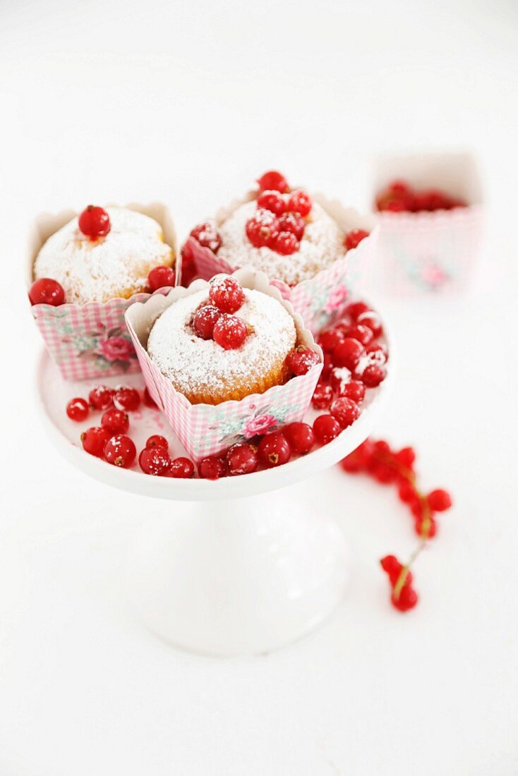 Redcurrant muffins decorated with icing sugar on a cake stand