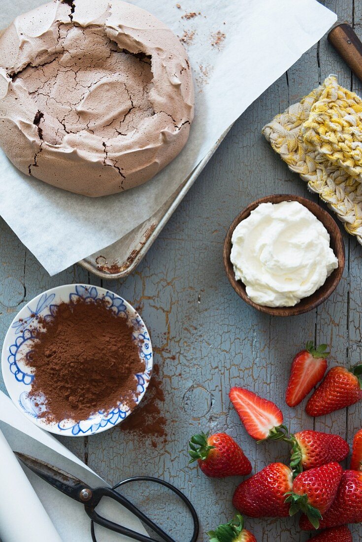 Ingredients for a chocolate pavlova with whipped cream and strawberries