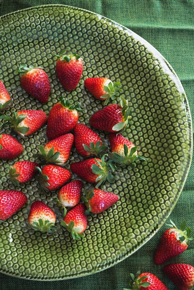 Strawberries on a green ceramic dish