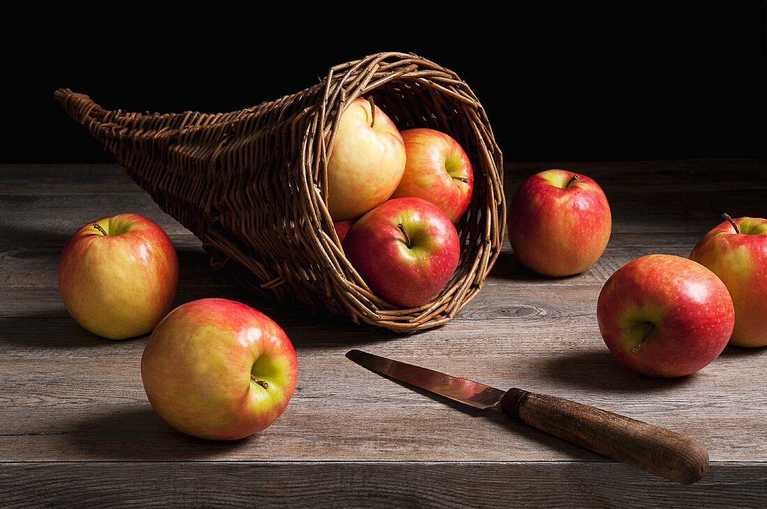 Apples in a cornucopia basket on a wooden table