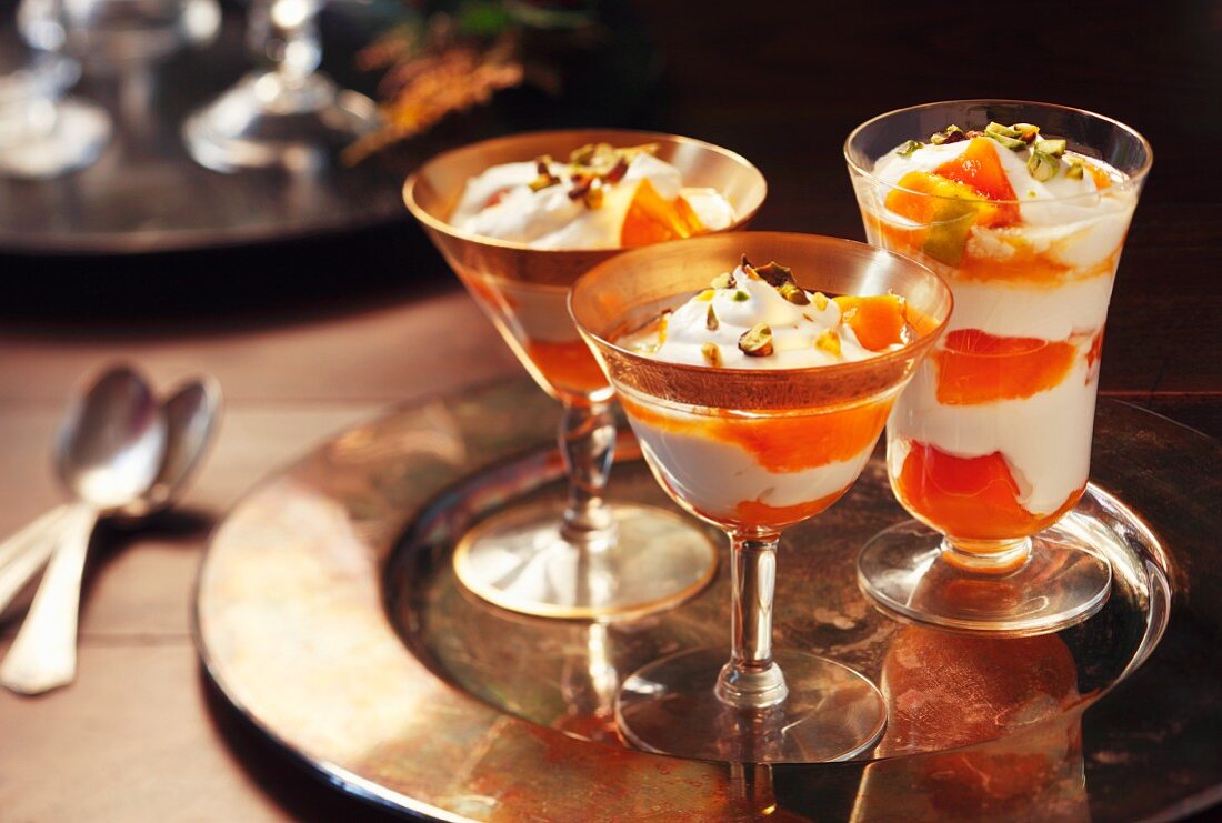 Mango trifle with pistachios in stemmed glasses