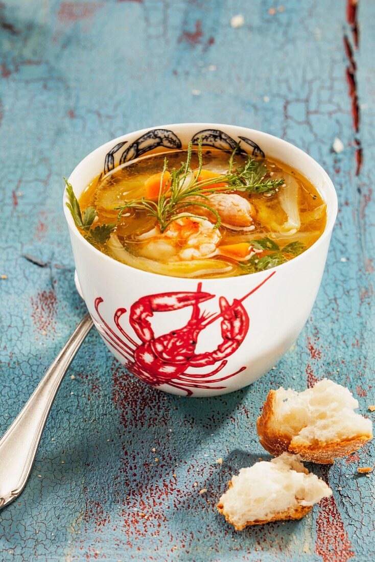 A cup of fish soup with prawns