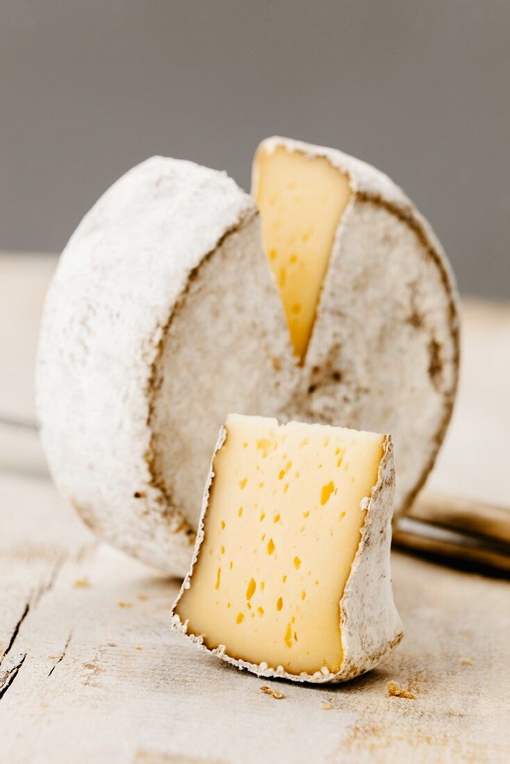 A wheel of Mutschli Swiss cheese, sliced