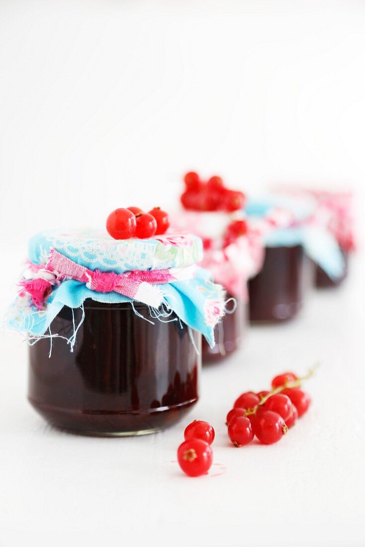 Jars of redcurrant jam with fabric covered lids