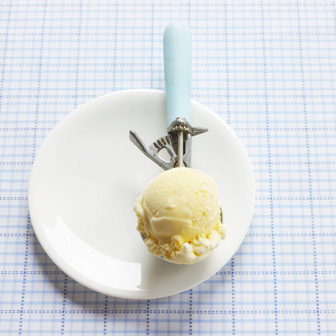 A scoop of lemon ice cream in an ice cream scoop