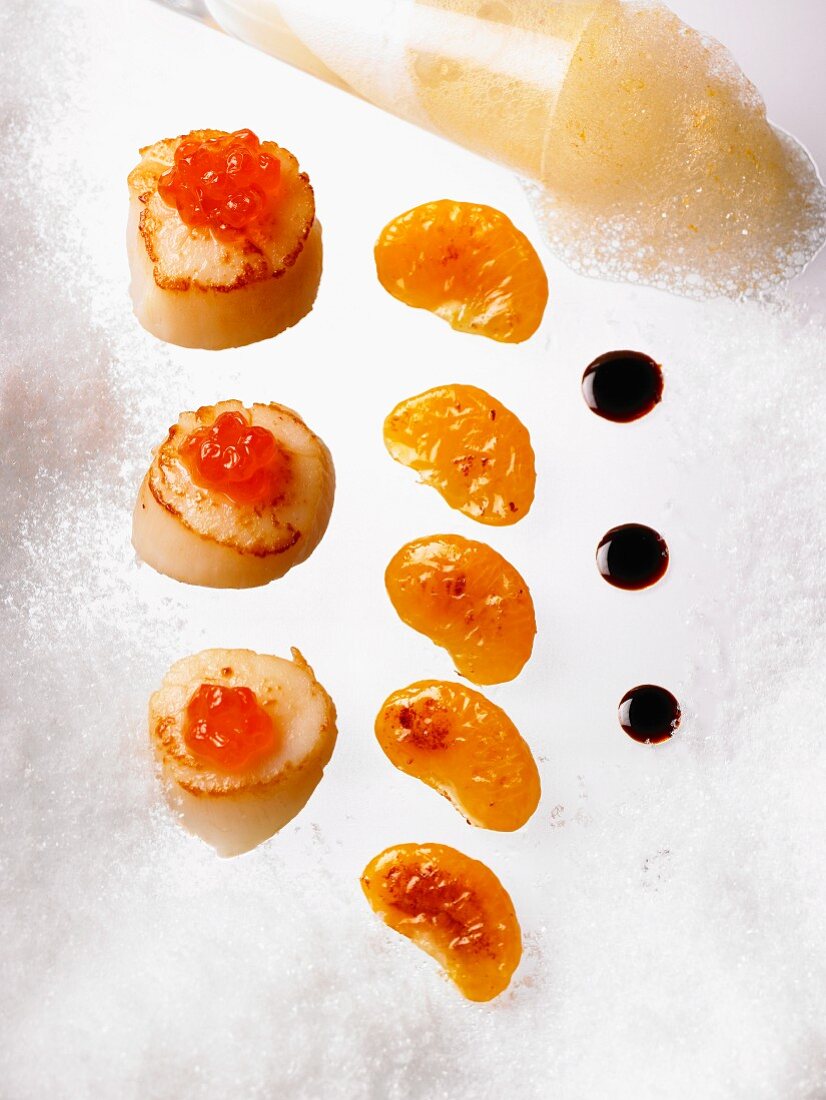 Scallops with salmon caviar, fried mandarin segments and a balsamic vinegar reduction