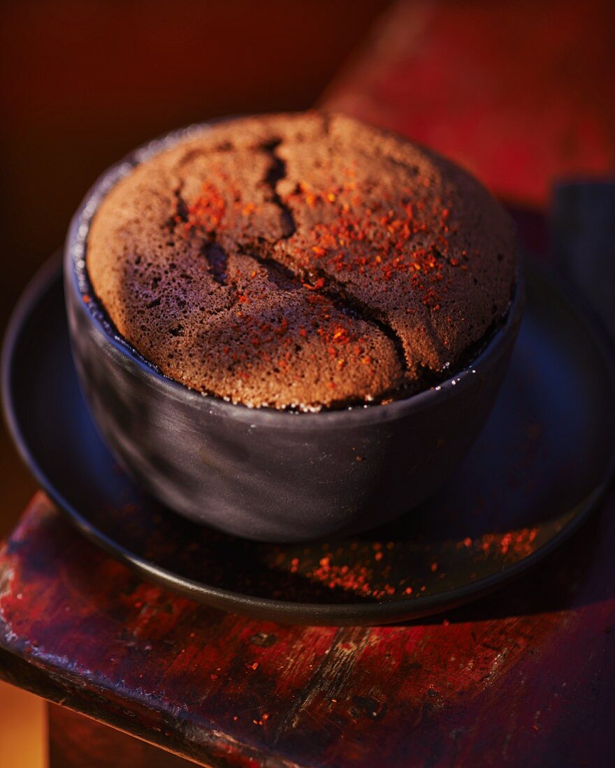 A chocolate soufflé in a dark grey baking tin