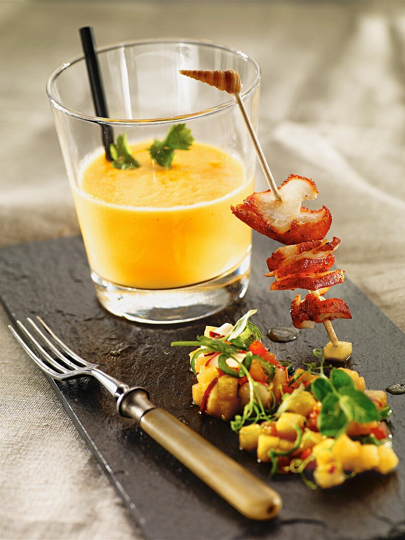 Cold carrot soup with a fried lobster skewer and mango salsa