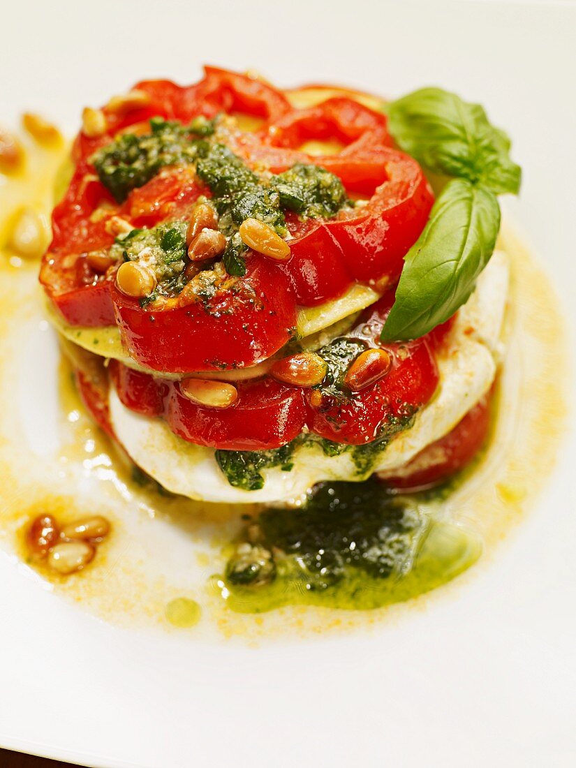 A beefsteak tomato with burrata, pesto and pine nuts