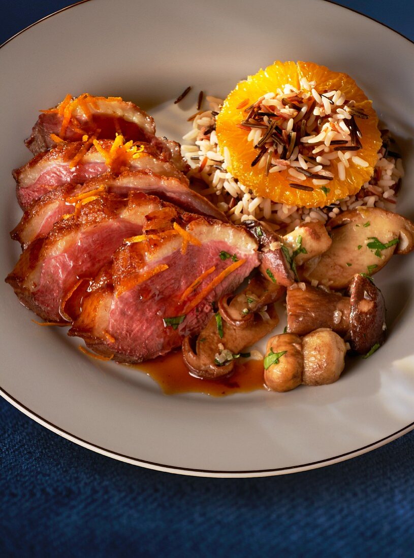 Duck breast with orange sauce, mushrooms and rice