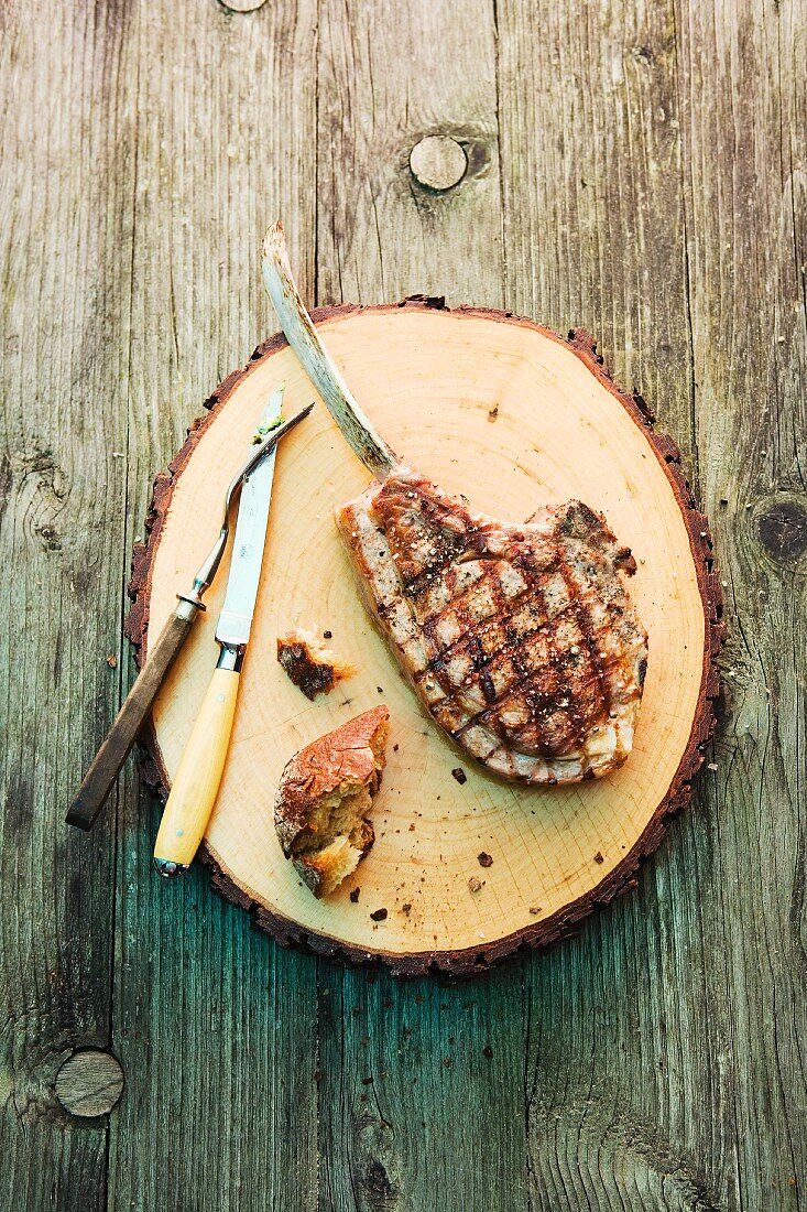 A grilled chop on a wooden plate