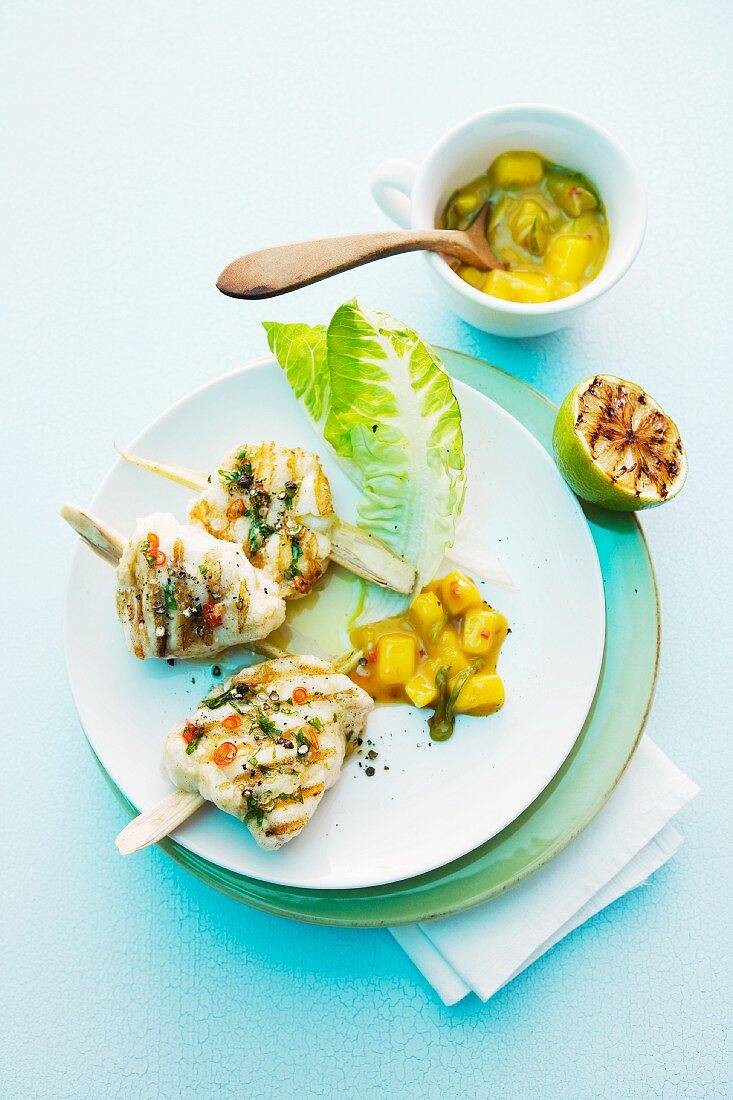 Grilled monk fish medallions speared on sticks of lemongrass with a mango and leek sauce