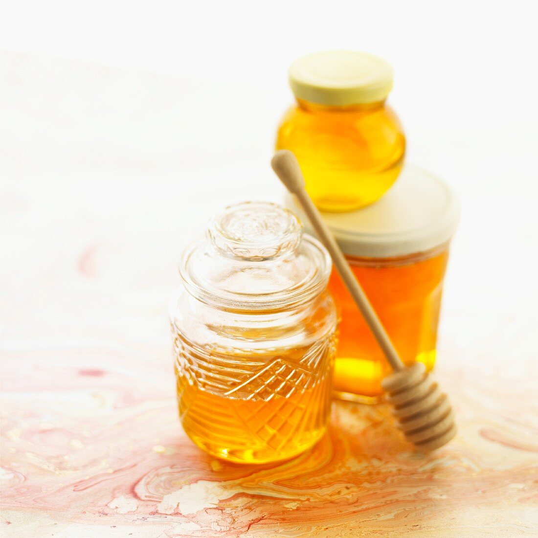 Jars of honey and honey dipper