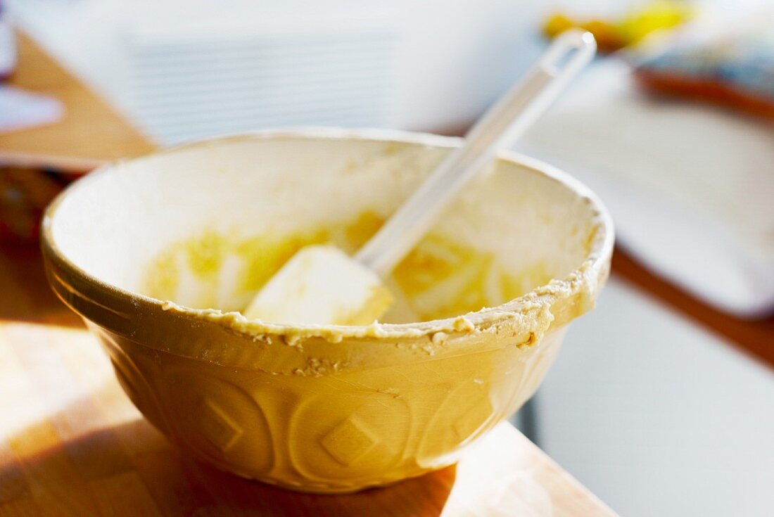 Remains of cake mixture in a mixing bowl with a spatula