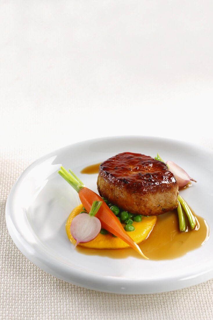 A pork medallion with spring vegetables