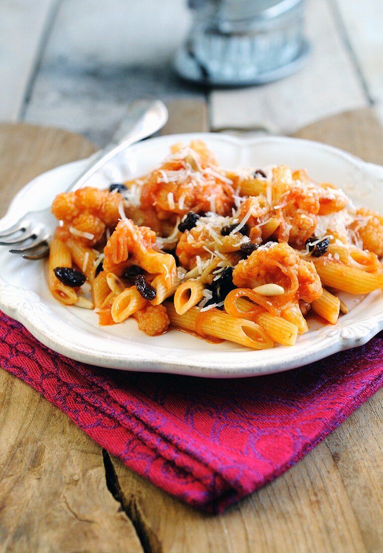 Penne pasta with cauliflower, raisins and tomato sauce