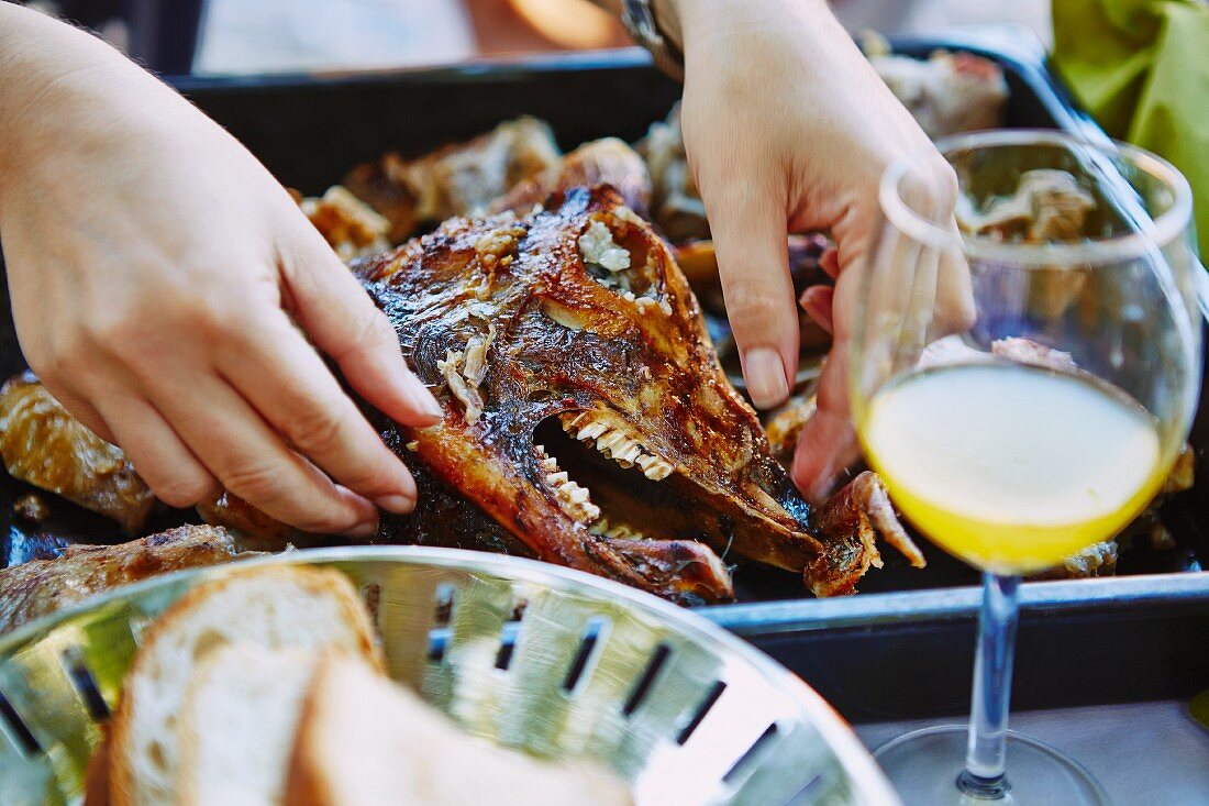 Grilled lamb and a lamb's head in a baking tray