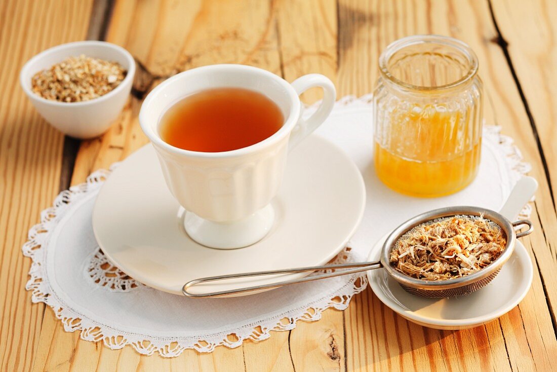 Bibernellen-Tee, Honig und getrocknete Teeblätter