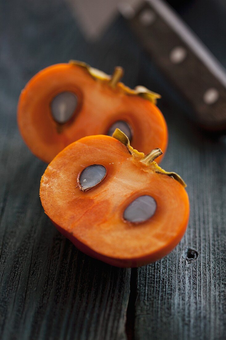 A sliced persimmon with seeds
