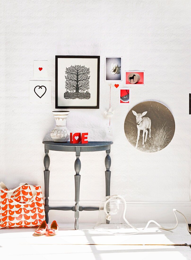 Wall lovingly decorated with pictures above console table