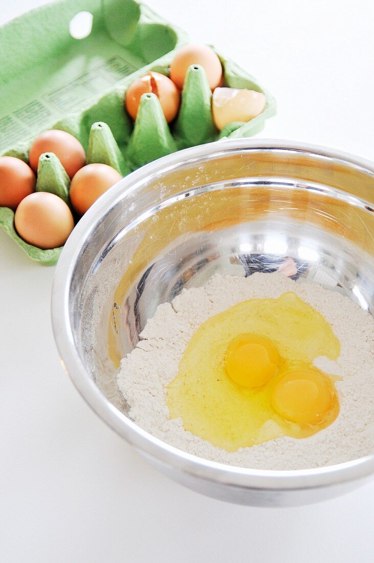 Mehl und aufgeschlagene Eier in Rührschüssel