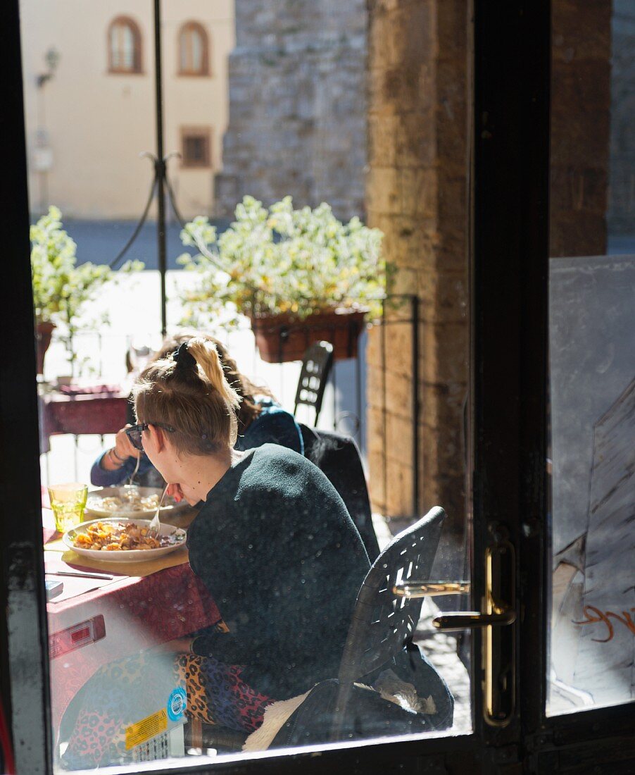 Leute in einem Stadtrestaurant in Massa Marittima (Toskana, Italien)