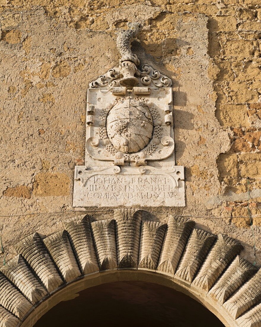 Historisches Wappen über einem Torbogen in der Stadt Pitigliano (Toskana, Italien)