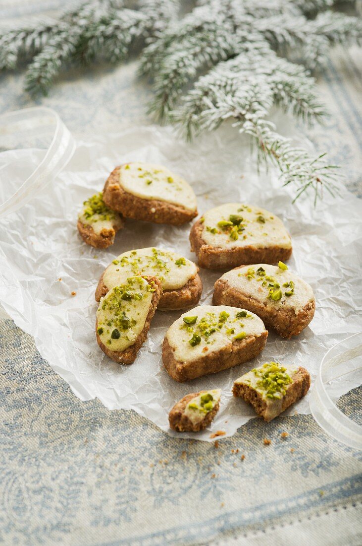 Christmas biscuits decorated with icing sugar and pistachios to look like open sandwiches