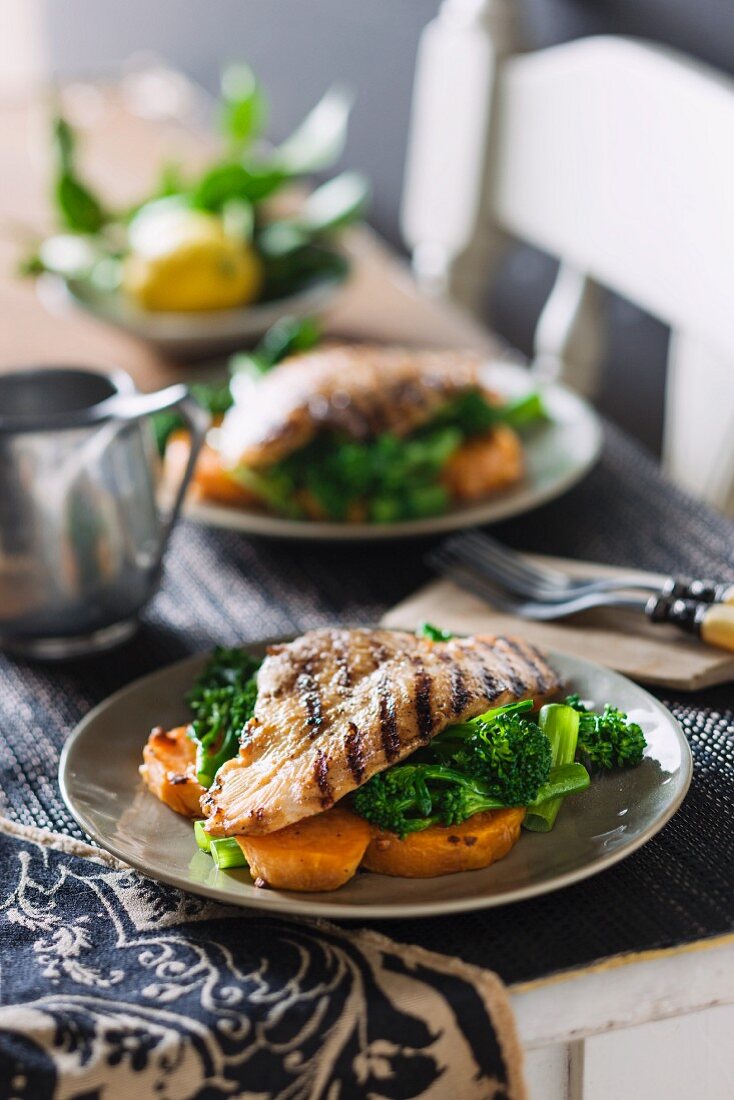Grilled barramundi fillets on a bed of sweet potatoes and broccoli